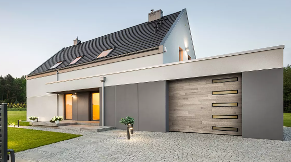Modern villa with a Clopay wood-look garage door featuring horizontal windows and a sleek grey facade.