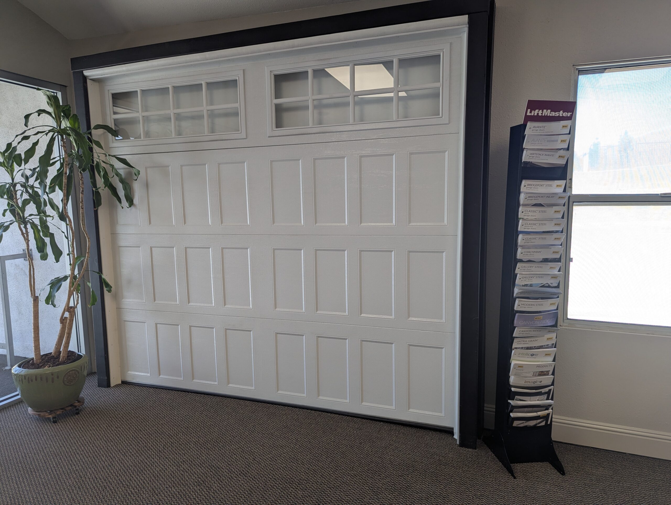 Full-size white garage door display and design brochures in the Redlands showroom