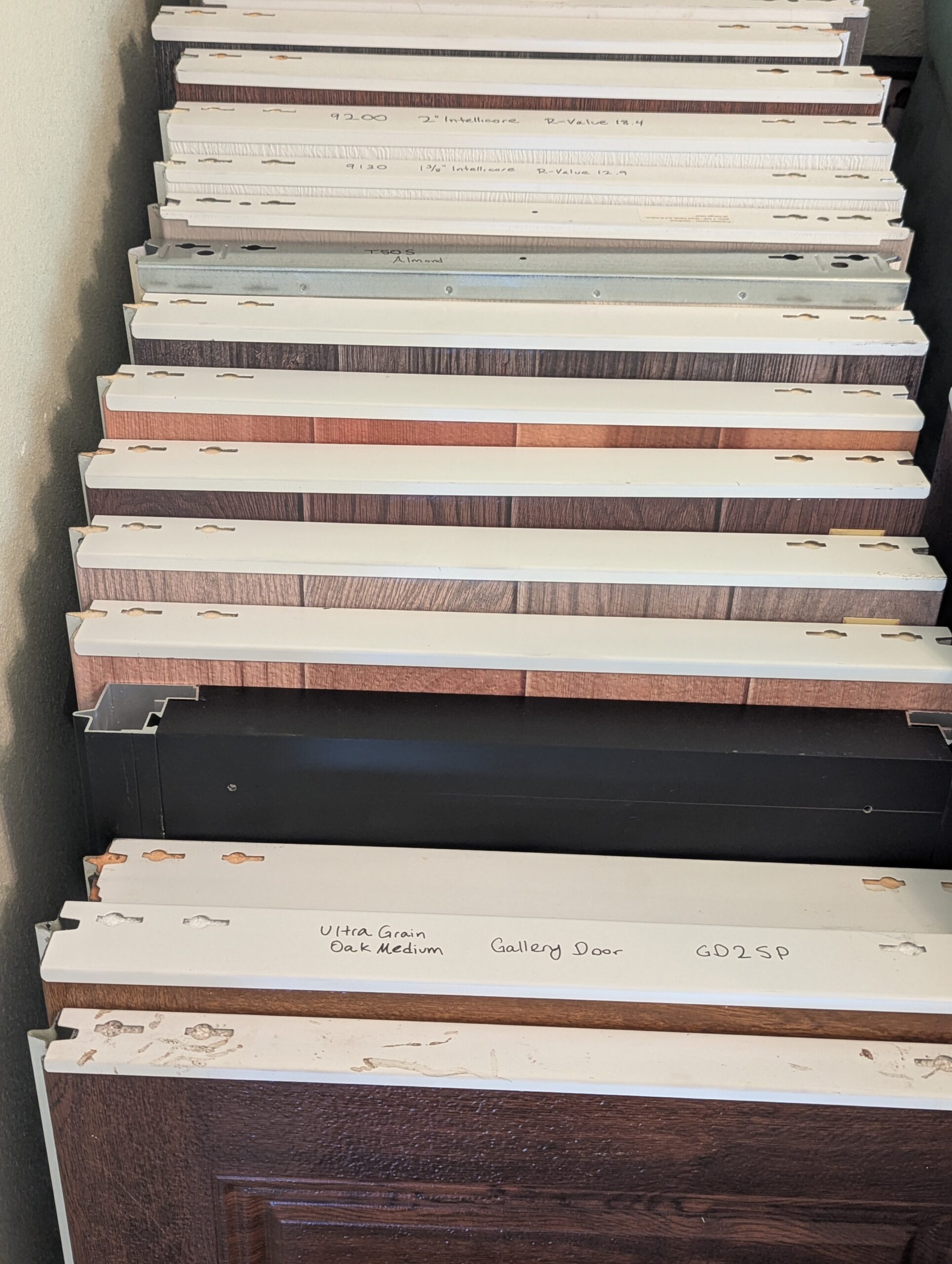 Full-size garage door section samples showing construction, colors, and woodgrain finishes