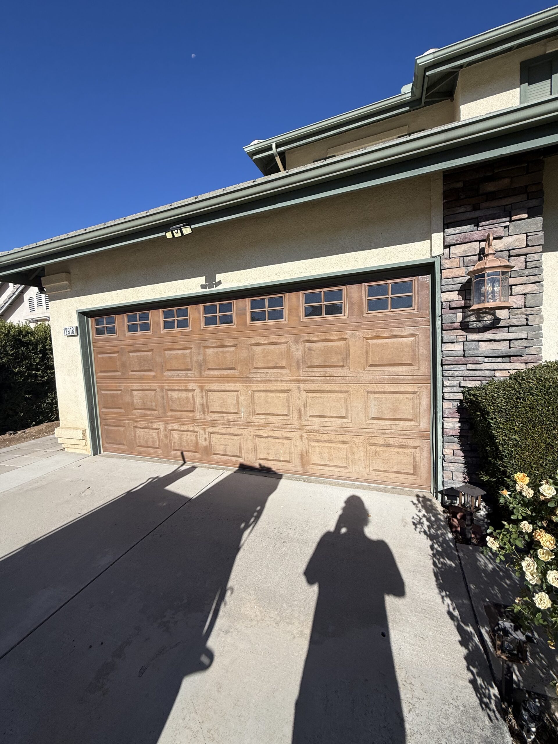 Weathered wood-look garage door before replacement at a Yucaipa home