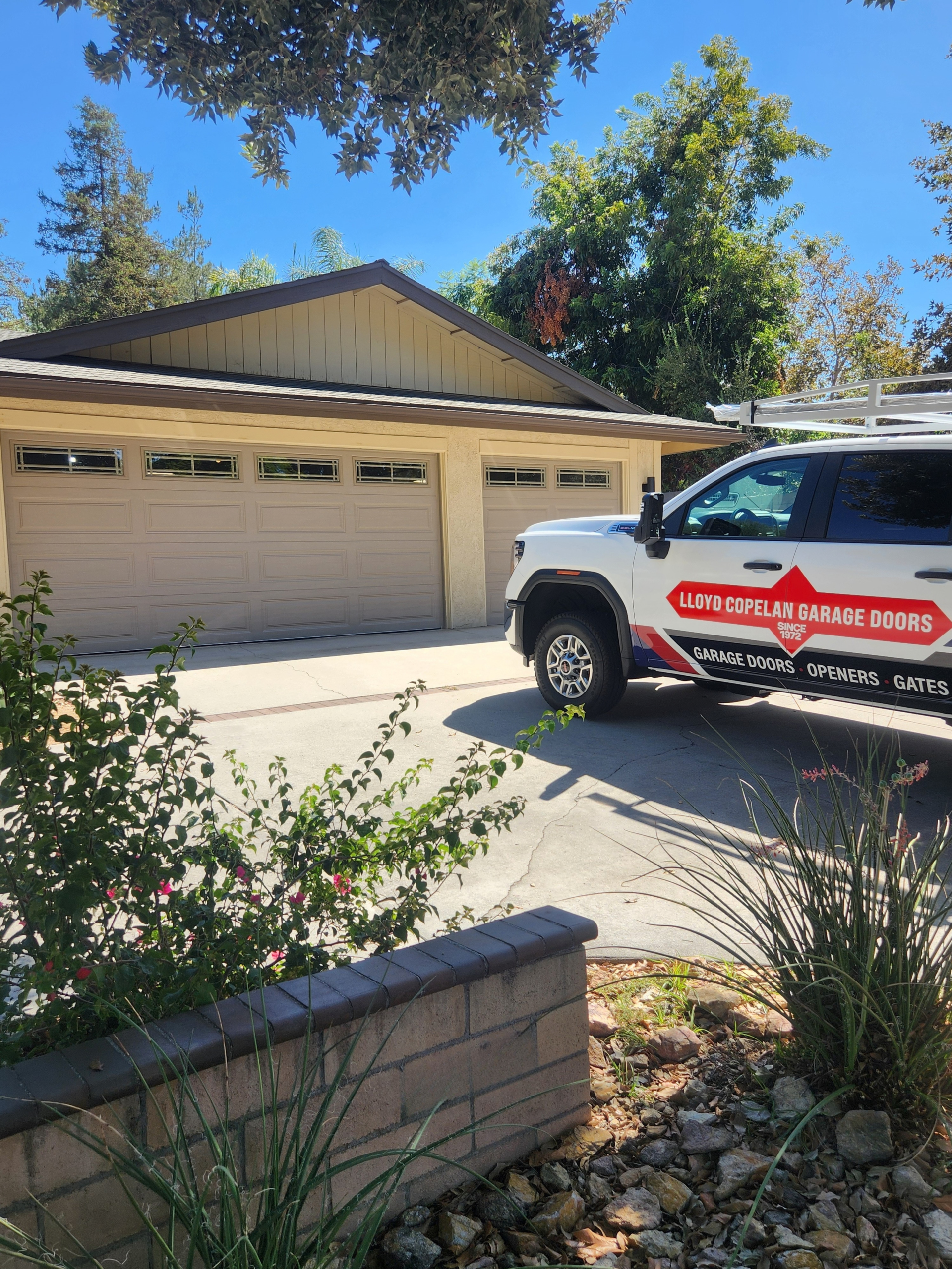 Lloyd Copelan service truck parked beside a completed classic steel garage door