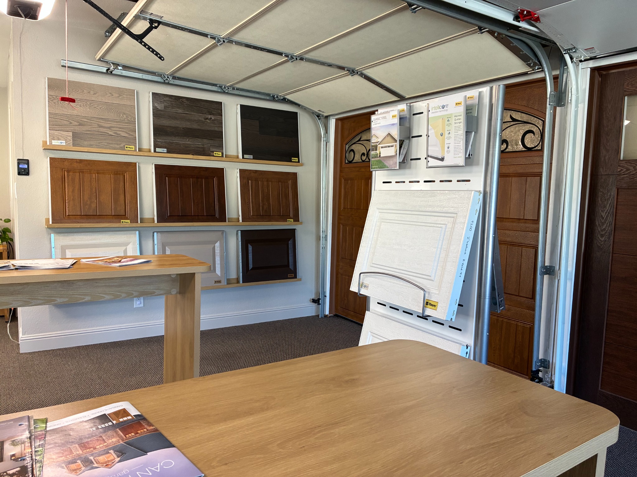 Redlands garage door showroom with full-size doors, finish samples, insulation displays, and consultation tables