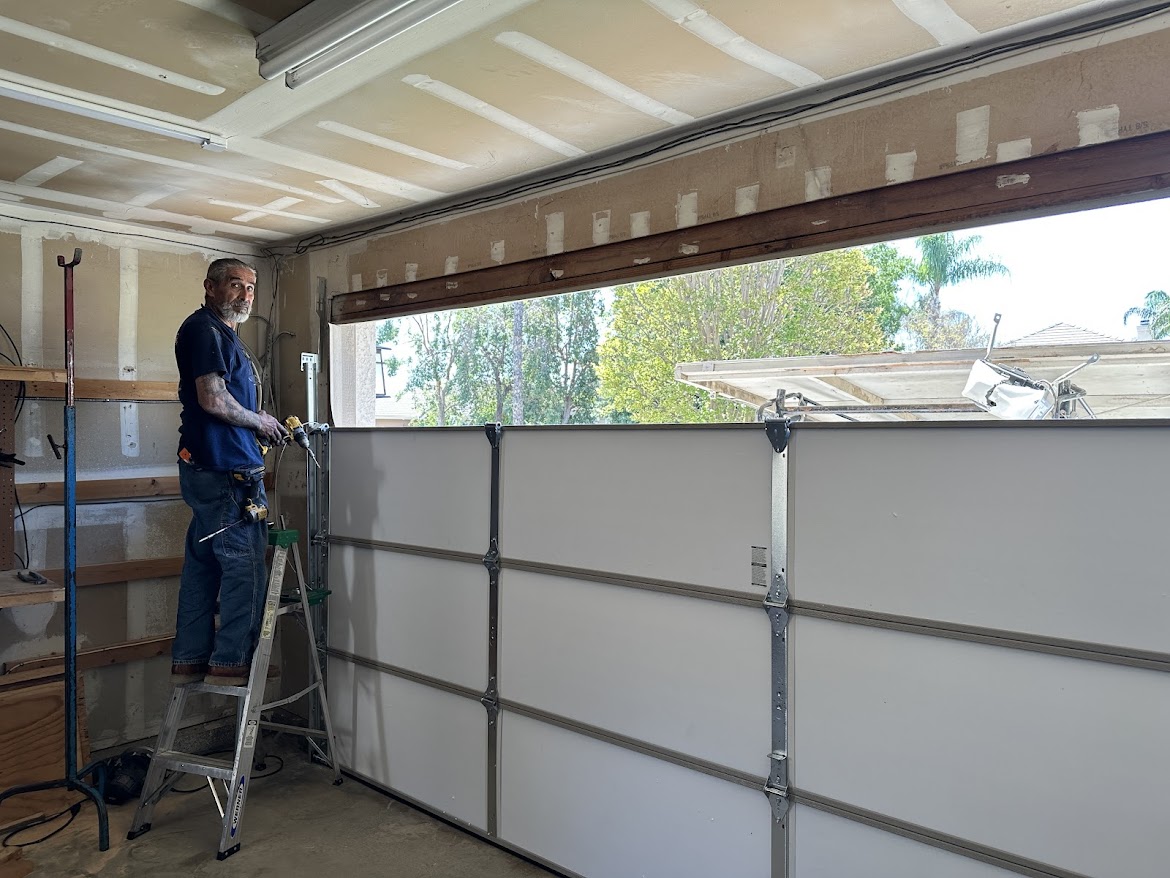 Lloyd Copelan technician installing a garage door inside a residential garage