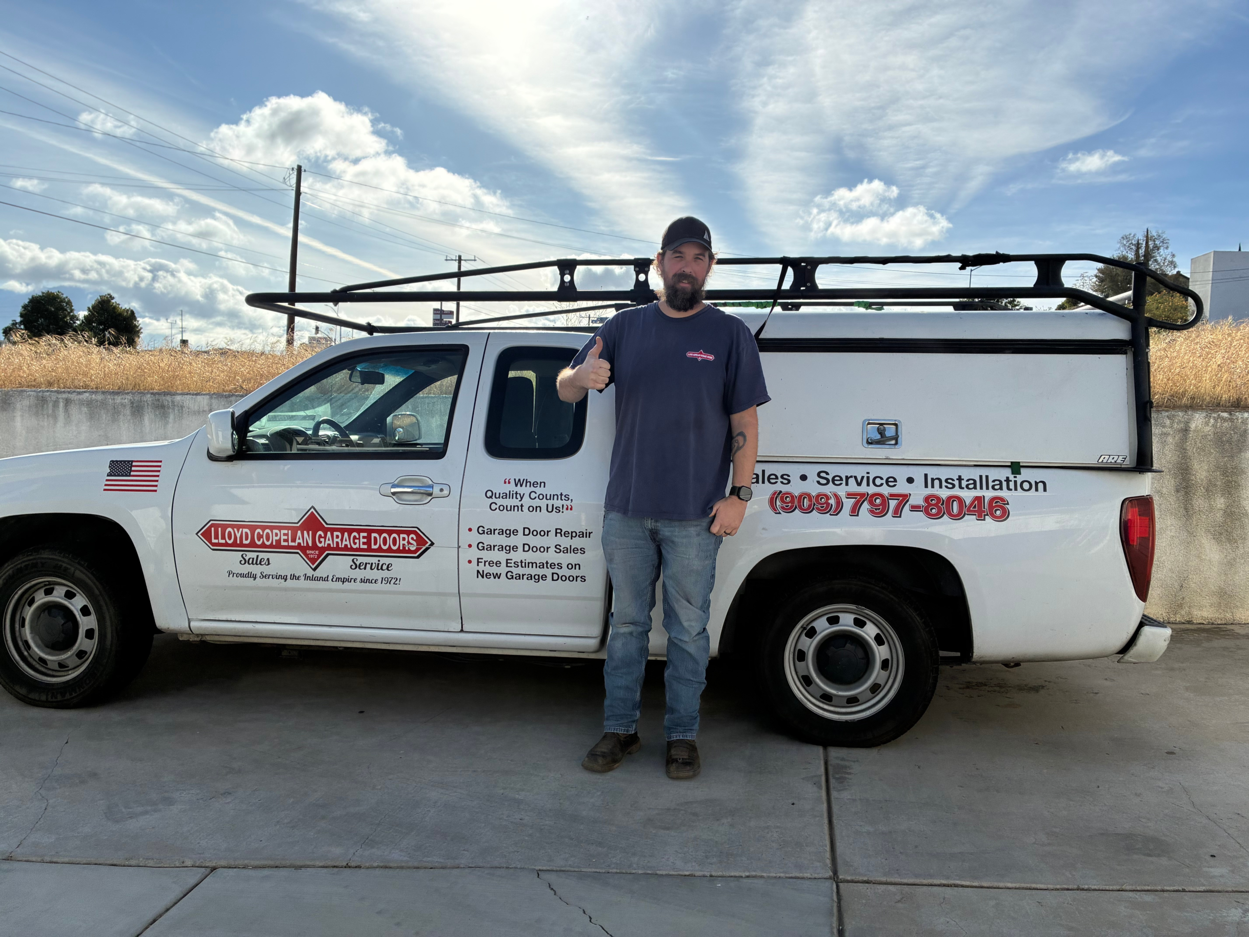 Lloyd Copelan technician beside a local garage door service truck
