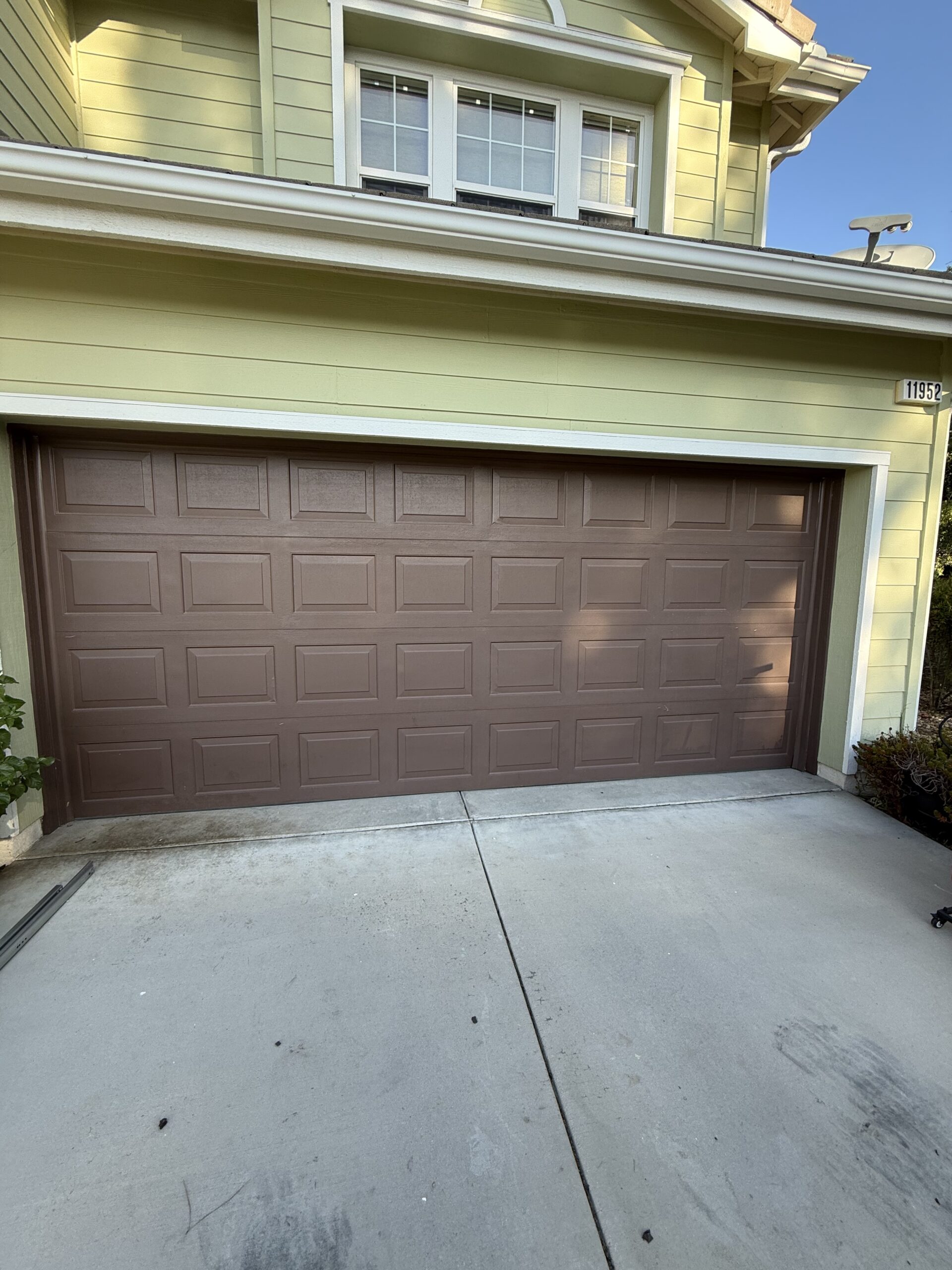 Before: existing garage door at a Yucaipa home before its Classic Steel door in Chocolate.