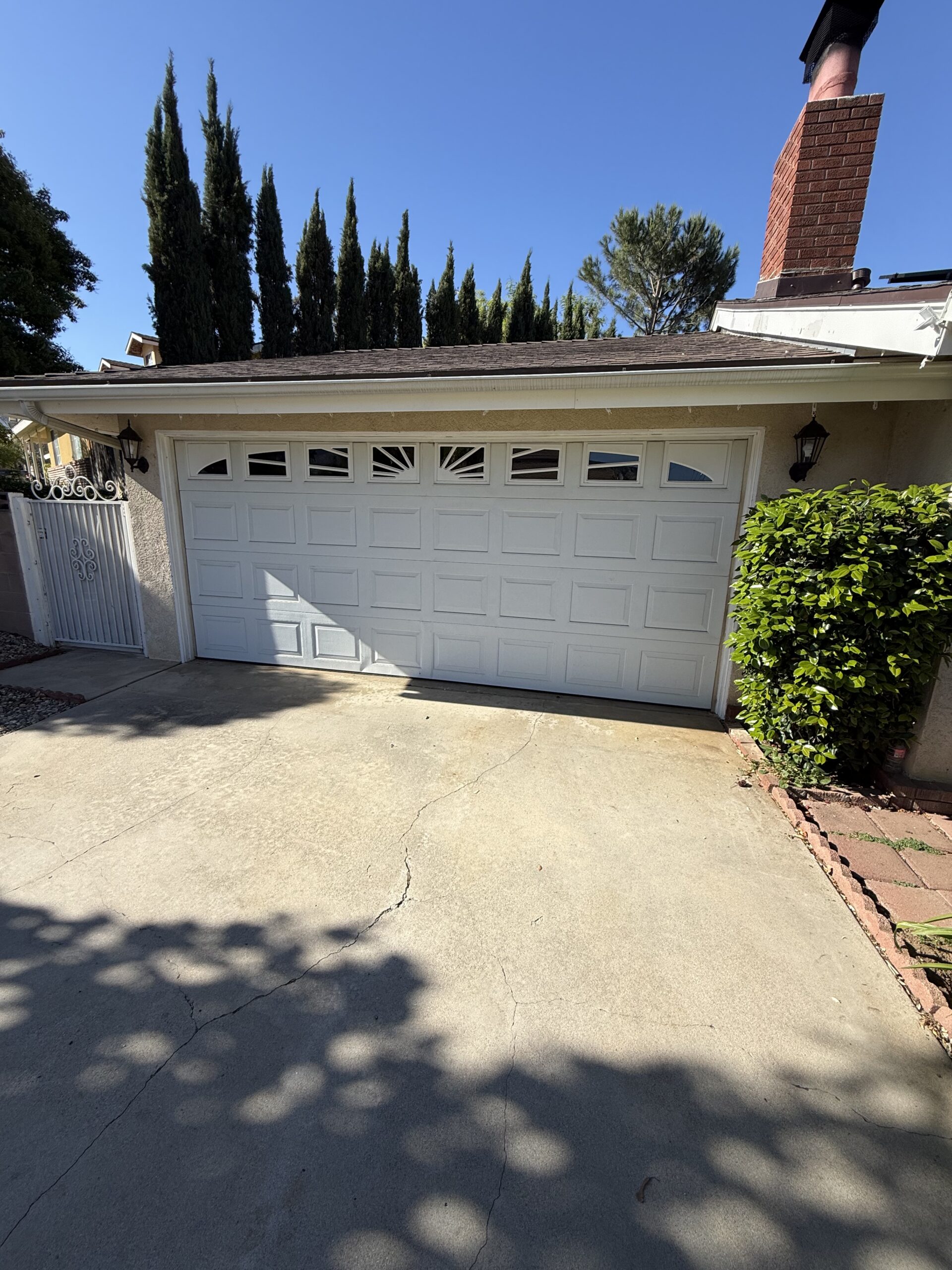 Before: existing garage door at a Yucaipa home before a bright white Long Panel refresh.