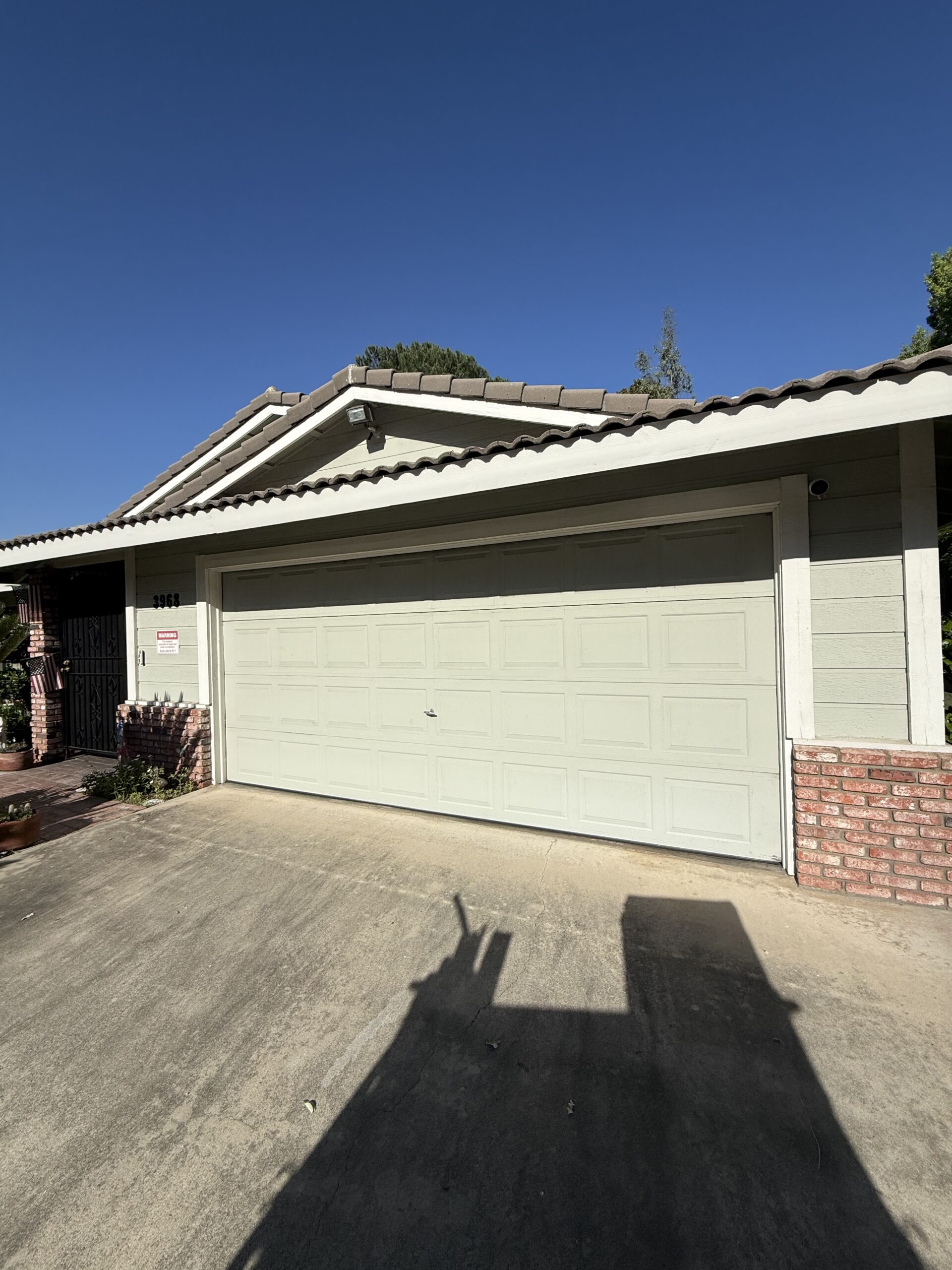 Before: existing white paneled garage door without windows.