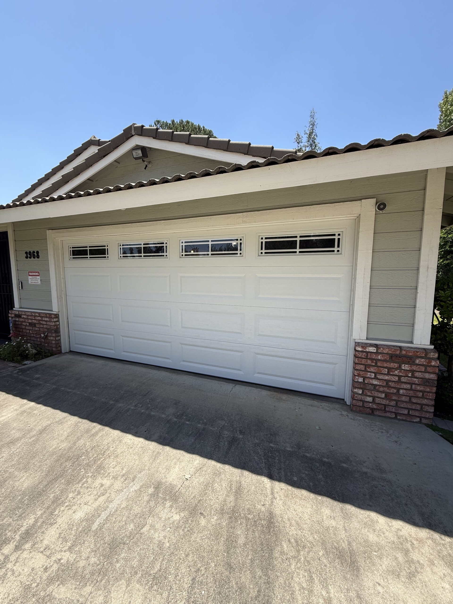 After: white paneled garage door with a row of top windows.